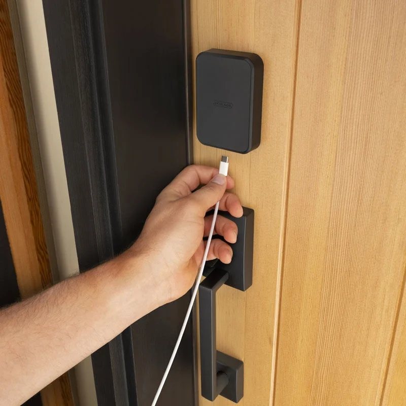 A USB-C cable connected to the emergency power port on a Schlage Sense Pro lock