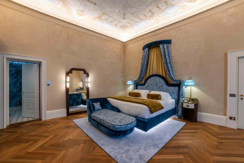 Palazzo Sogni 客房内的蓝色软包床头、贵妃椅与全身镜